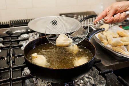 Photo for Detail of the preparation of fried ravioli in a pan full of oil in a traditional kitchen - Royalty Free Image