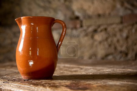 Foto de Hermosa jarra de cerámica aislada en la vieja mesa de madera - Imagen libre de derechos