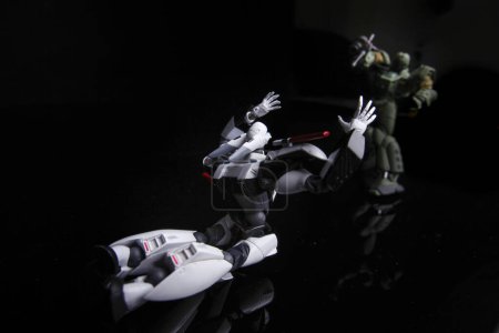 Foto de 2 Toy Robots luchan contra un desafío épico, aislado sobre fondo negro - Imagen libre de derechos