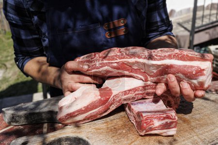 Téléchargez les photos : Mains tenir des morceaux de viande prêts à être cuits - en image libre de droit