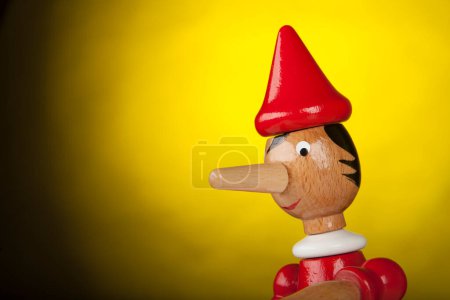 Téléchargez les photos : Pinocchio jouet en bois sur fond jaune - en image libre de droit