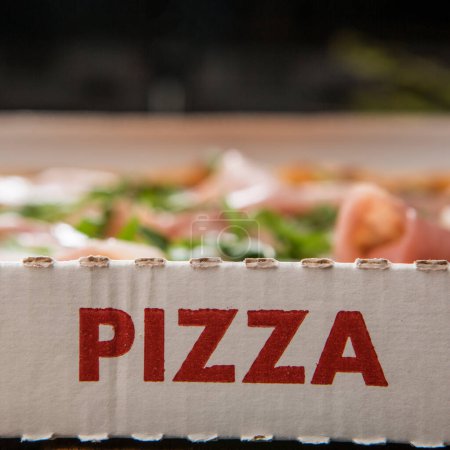 Foto de Cartón con la pizza de inscripción fuera y dentro de la pizza listo para ser entregado, isoalta en una mesa de madera - Imagen libre de derechos