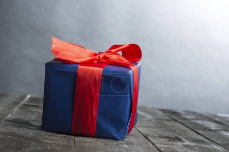 Téléchargez les photos : Coffret cadeau bleu avec noeud rouge sur table en bois, isolé sur fond blanc - en image libre de droit