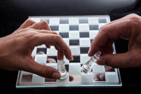 Téléchargez les photos : Mains de deux hommes jouant des pièces d'échecs dans le jeu. - en image libre de droit