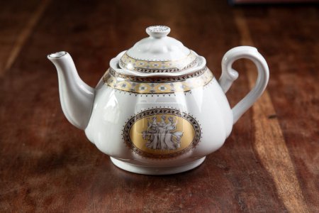 Photo for Refined ceramic teapot, isolated on a table inside a house - Royalty Free Image