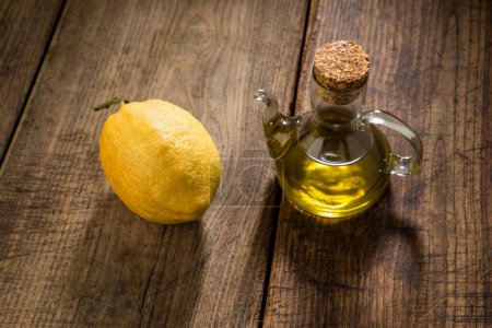 Téléchargez les photos : Cruette au citron et à l'huile isolée sur table en bois - en image libre de droit