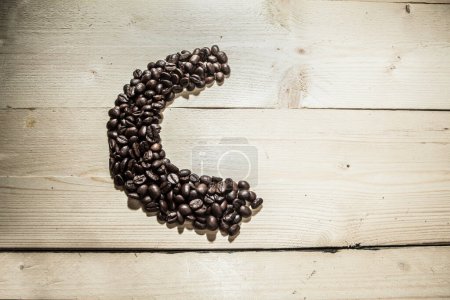 Téléchargez les photos : Écrit "C" sur des planches en bois avec grains de café - en image libre de droit