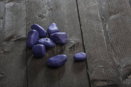 Photo for Purple colored stones on a wooden table - Royalty Free Image