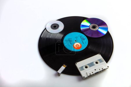 Téléchargez les photos : Vieux lecteur de cassettes avec disque vinyle sur fond blanc - en image libre de droit