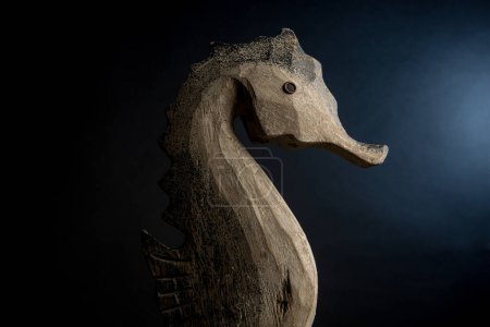 Téléchargez les photos : Sculpture d'un hippocampe en bois, isolé sur fond noir - en image libre de droit