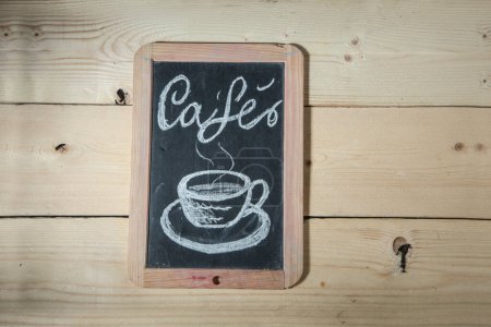 Photo for Black chalkboard on wooden background with the inscription: "caf" and the drawing of a cup - Royalty Free Image