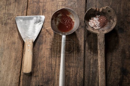 various vintage tools with colored salt above, isolated on wood background