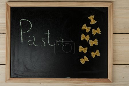 Téléchargez les photos : Tableau noir de l'école sur table en bois avec "Pâtes" écrit dessus - en image libre de droit
