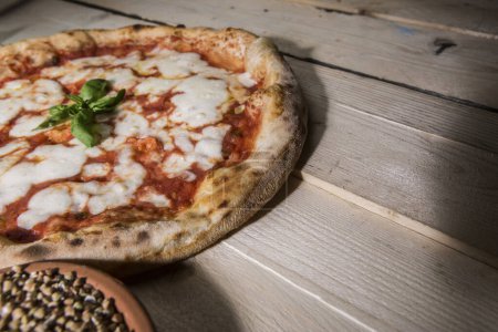Téléchargez les photos : Pizza tomate ronde sur une table en bois - en image libre de droit