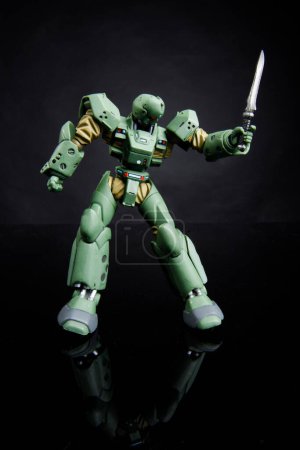 Foto de Robot de juguete de color verde menea espada, aislado sobre fondo negro - Imagen libre de derechos