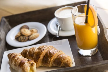 Photo for Italian breakfast with cappuccino, croissants, orange juice and biscuits - Royalty Free Image