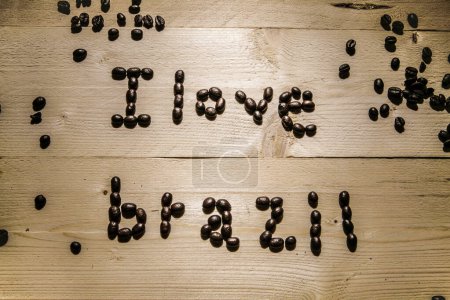 Téléchargez les photos : Écrit avec des grains de café "J'aime le Brésil" sur une table en bois - en image libre de droit