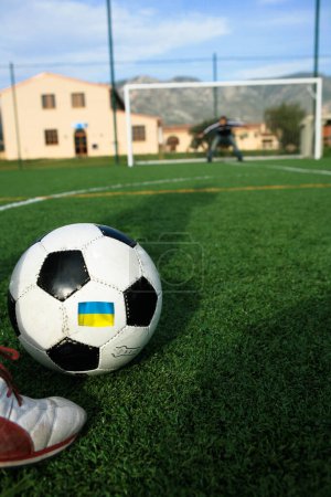 Foto de Pelota de fútbol con por encima de la bandera con los colores de Ucrania, mientras que tomar una pena - Imagen libre de derechos