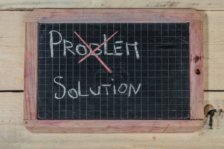 Téléchargez les photos : Tableau noir de l'école sur table en bois avec "solution de problème" écrit dessus - en image libre de droit
