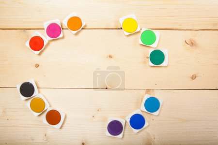 Foto de Círculo de acuarelas de colores sobre fondo de madera clara - Imagen libre de derechos