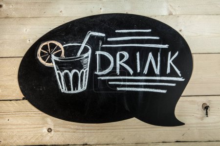 Photo for Black chalkboard on wooden background with the inscription: "drink" and the drawing of a glass - Royalty Free Image