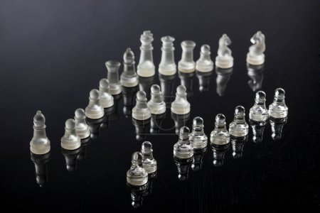 Photo for Glass chess pieces, arranged on a dark and transparent surface - Royalty Free Image