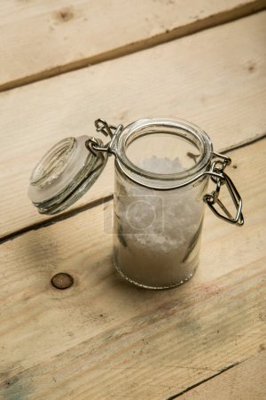 Téléchargez les photos : Petit récipient en verre pour sel grossier sur une table en bois - en image libre de droit