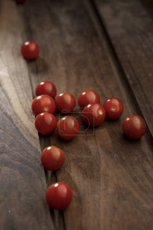 Foto de Ramo de tomates descansando sobre una mesa de madera - Imagen libre de derechos