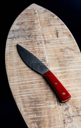 Photo for Knife with red handle isolated on wooden tray - Royalty Free Image