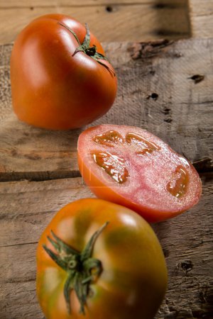 Photo for Bunch of tomatoes resting on a wooden table - Royalty Free Image