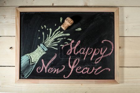 Téléchargez les photos : Tableau noir sur fond en bois avec l'inscription : "Bonne année " - en image libre de droit