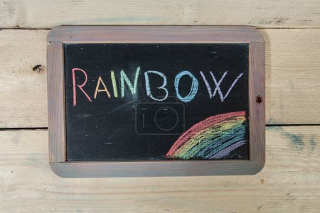 Téléchargez les photos : Tableau noir de l'école sur table en bois avec "Rainbow" écrit dessus - en image libre de droit