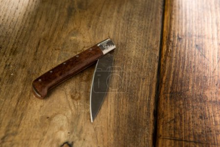 Foto de Cuchillo de tipo sardo semi-cerrado sobre fondo de madera - Imagen libre de derechos