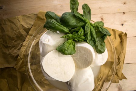 Photo for Buffalo mozzarella in a glass container on a wooden table - Royalty Free Image