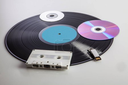 Photo for Vinyl record with other various digital media from different eras such as cassettes, dvds, pen-drives, isolated on a white background - Royalty Free Image