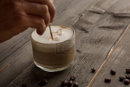 Foto de Cappuccino con espuma con granos de café sobre una mesa de madera - Imagen libre de derechos