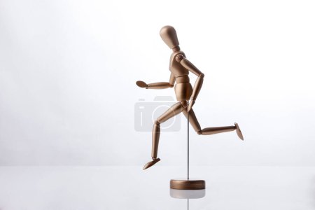 Photo for Wooden puppet moves with determined stroke, isolated on white background - Royalty Free Image