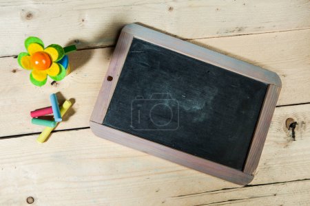 Photo for School blackboard on wooden table with various items on the table - Royalty Free Image