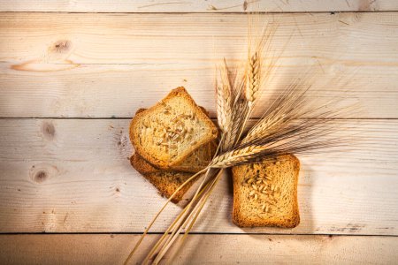 Photo for Bread and spikelets on old wooden background - Royalty Free Image