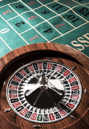 Foto de Ruleta de madera aislada sobre una mesa de juego verde - Imagen libre de derechos