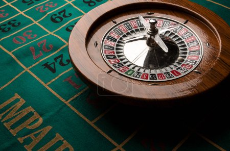 Photo for Wooden roulette isolated over a green gaming table - Royalty Free Image