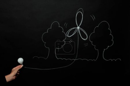 Photo for Hand drawing on blackboard and showing a light bulb - Royalty Free Image