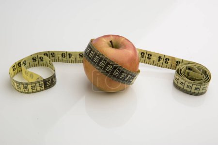 Téléchargez les photos : Pomme avec compteur à mesurer sur fond blanc - en image libre de droit