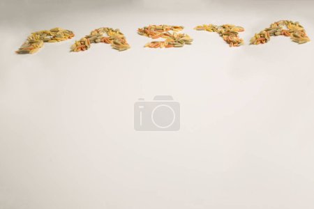 Téléchargez les photos : Pâtes écrites avec malloreddus sur une table blanche - en image libre de droit