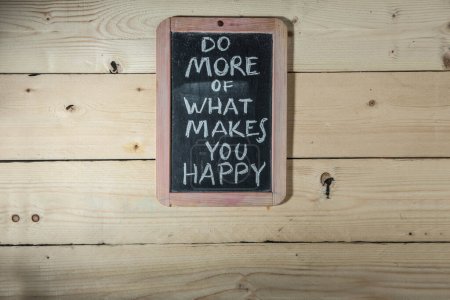 Téléchargez les photos : Tableau noir avec l'inscription "faire plus de ce qui vous rend heureux" - en image libre de droit