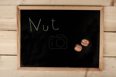 Téléchargez les photos : Tableau noir de l'école sur table en bois avec "Nut" écrit dessus - en image libre de droit