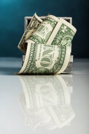 Foto de Billetes de dólar enrollados, sobre un fondo azul - Imagen libre de derechos