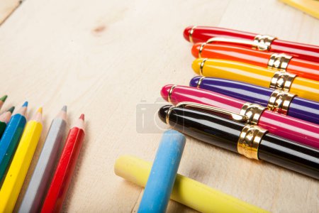 Téléchargez les photos : Crayons de couleur et stylos sur table en bois - en image libre de droit