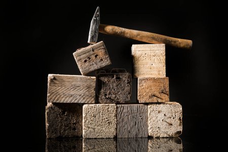 Photo for Hammer near of square wooden logs, isolated on black background - Royalty Free Image