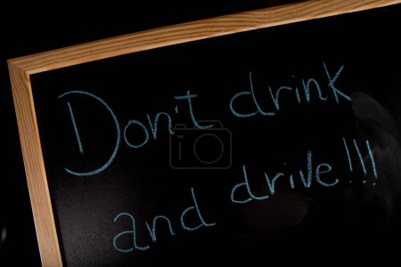 Foto de Escrito "no beber y conducir!!!" dibujado en tiza en la pizarra sobre una mesa - Imagen libre de derechos
